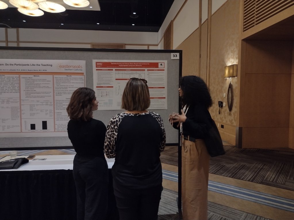 scholar presenting poster to conference attendees