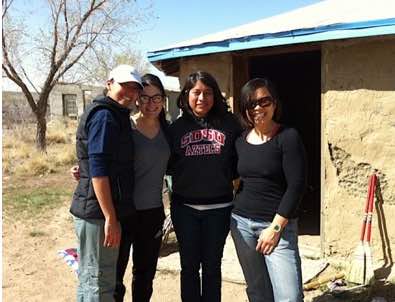 Photo: 3 young women pose in front of adobe dwelling t March 2012 retreat, Shiprock, New Mexico (Tsedaak'aan, Diné Nation)