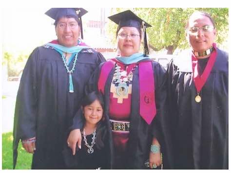 Photo: May 10, 2008: Eugene Honanie, Elvina Charley and Brent Toadlena at graduation, all are in graduation regalia as well as native accessories, and a little girl poses with them