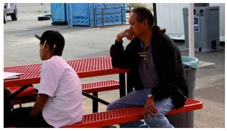 Photo: Larry Emerson and young boy sit at outdoor red table.
