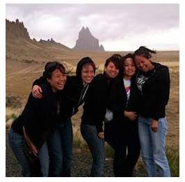 Photo: Group of NAISC women laughingly pose for photo in front of Ship Rock 