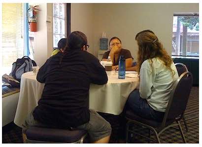 Photo: Students talking while seated at table