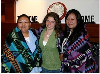 Photo: 3 NAISC scholars pose, 2 of them are wearing Native American blankets