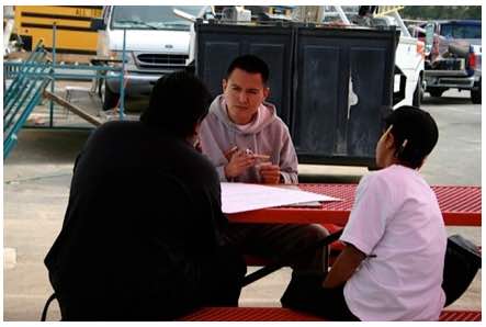 Photo: NAISC scholar at outdoor table with young students