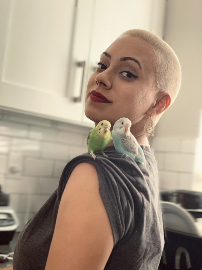fatima wearing a gray shirt with two birds on shoulder