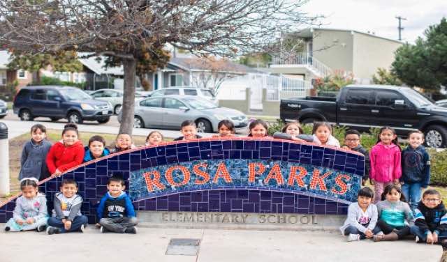 Photo: Children pose in front of Rosa Parks elementary school sign