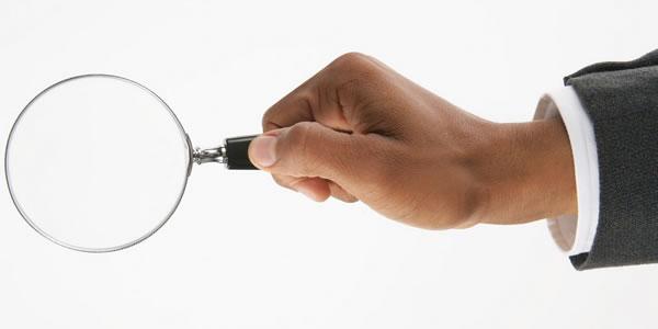 Hand holding a magnifying glass.