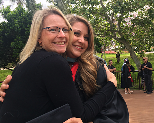 Faculty member, Rebecca Koo, embraces Sarah Zillweger on her graduation day