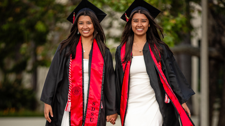 Identical twins Sabrina and Sydney Moreno pose in caps and gowns